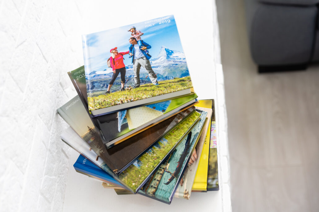 Stack of photo albums showcasing travel and family memories, symbolizing the value of creating and preserving a personal legacy over time.