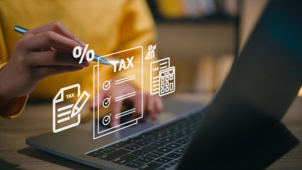 Corporate and individual tax payment concept, woman using comput Person using a stylus to navigate tax documents on a laptop with digital tax icons