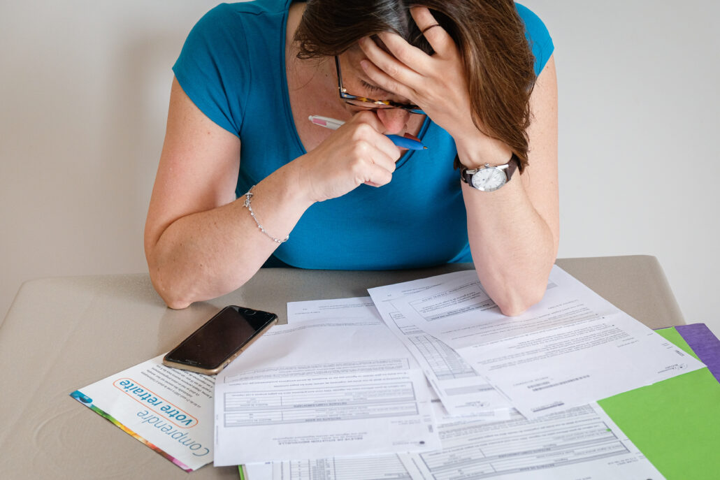 Doctor reviewing financial paperwork and retirement withdrawal strategy with concern.