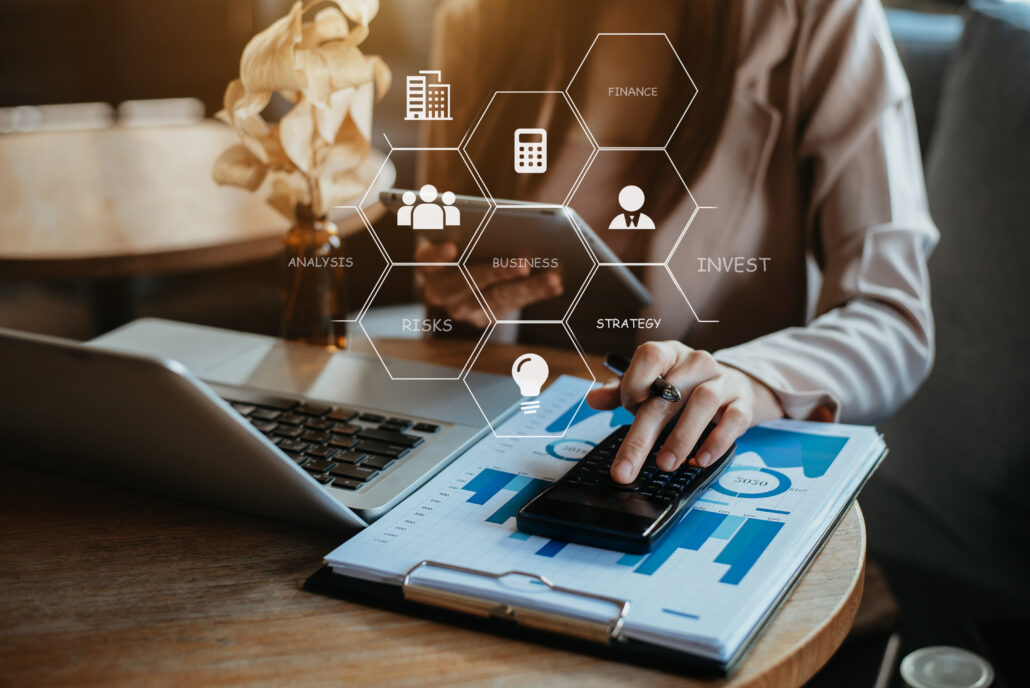 Professional reviewing Q1 tax planning data on a laptop and calculator with charts on a clipboard