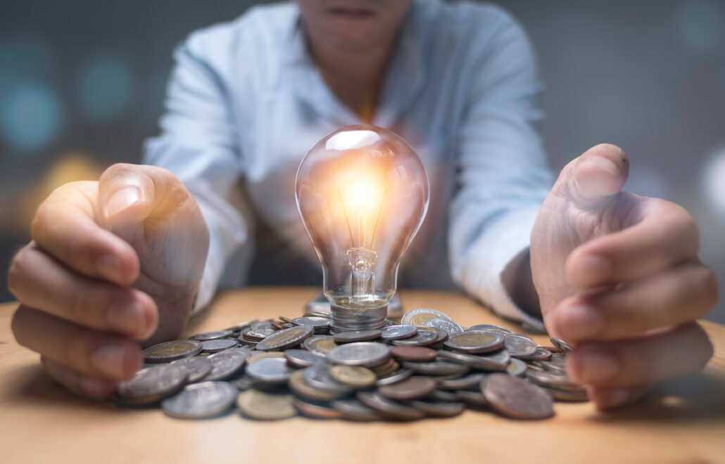 Physician reviewing finances with a glowing lightbulb over a pile of coins symbolizing smart January tax planning