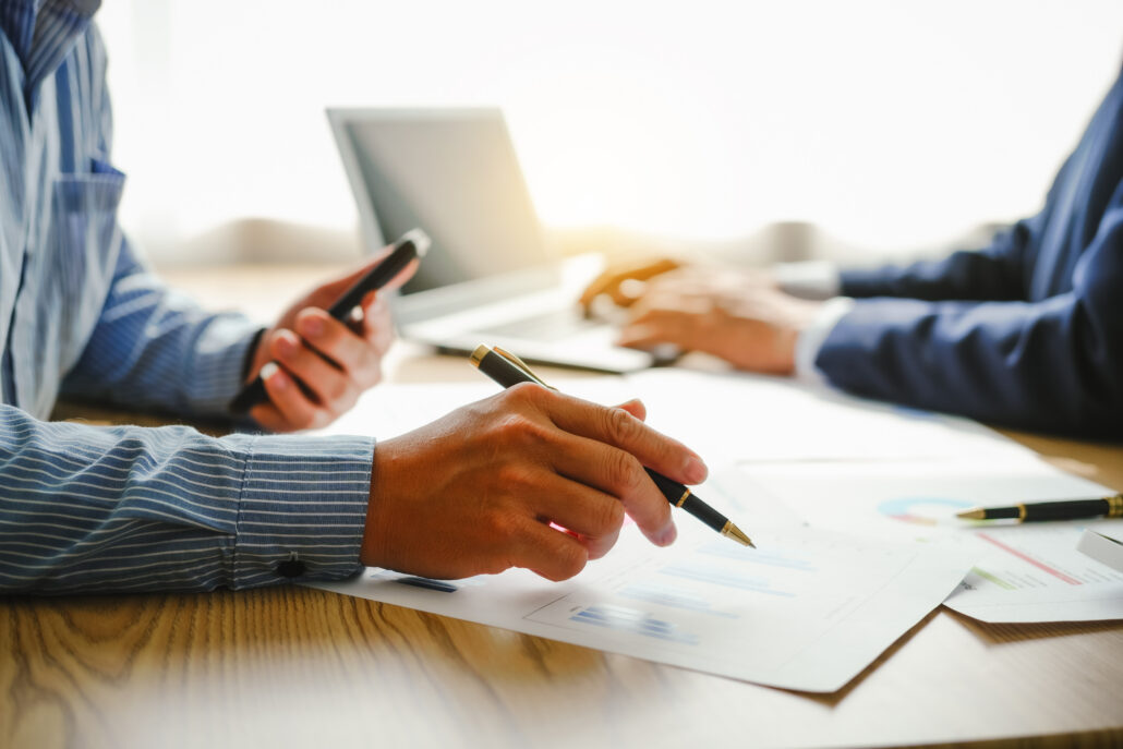 Physician reviewing financial reports and tax documents while calculating multiple income sources at an office desk